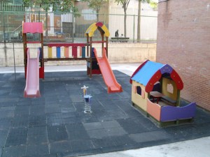El patio de los columpios junto al edificio de infantil